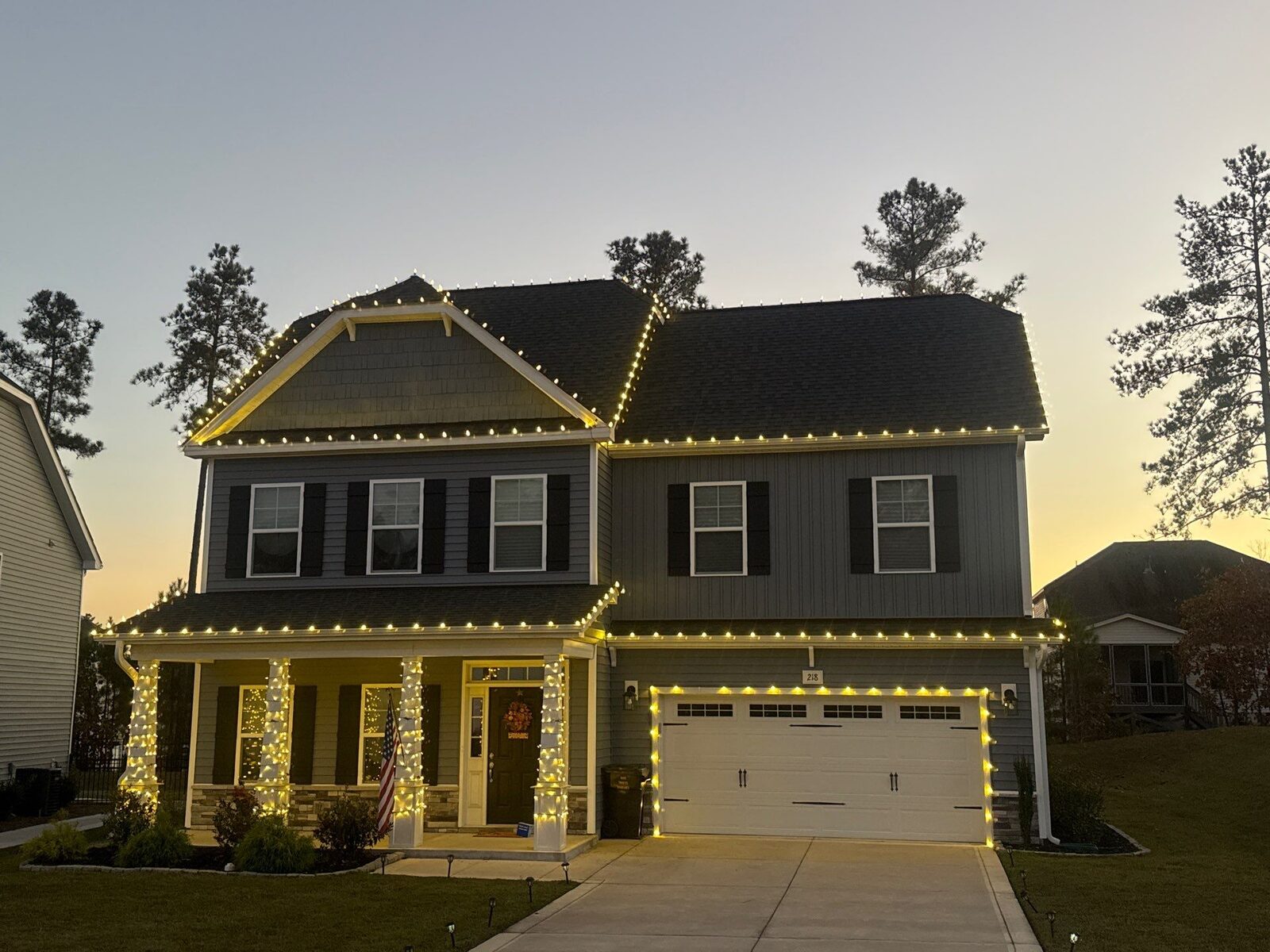 Home with Christmas roofline lights and wrapped porch columns